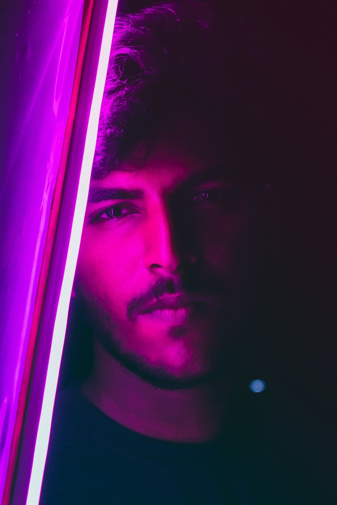 A creator lit in magenta light in a home studio